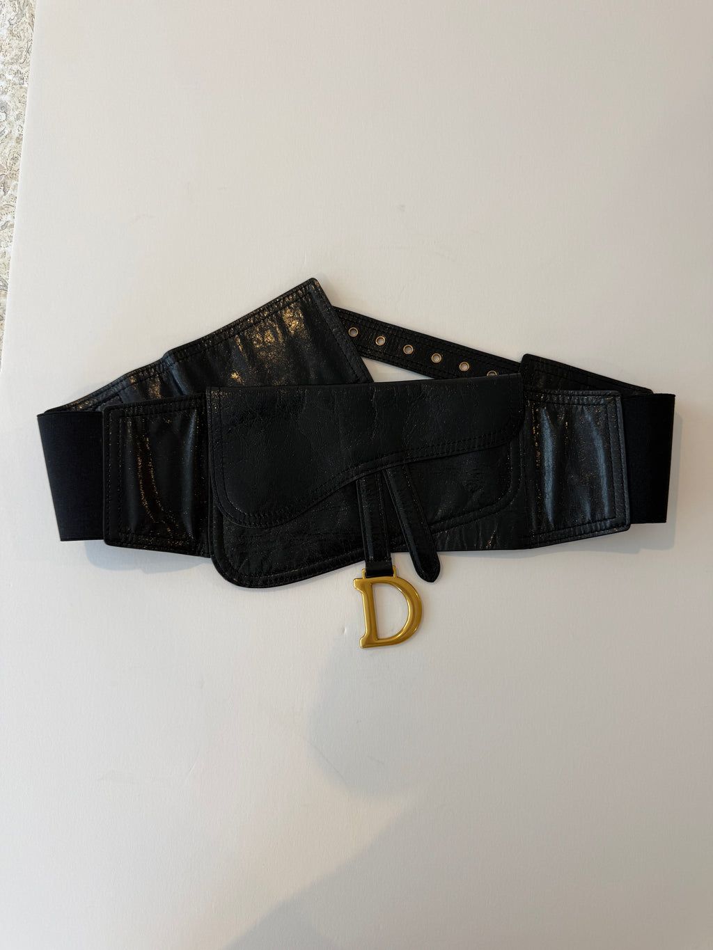 Close-up of black calfskin Saddle flap with gold-tone D charm loop on Christian Dior belt bag