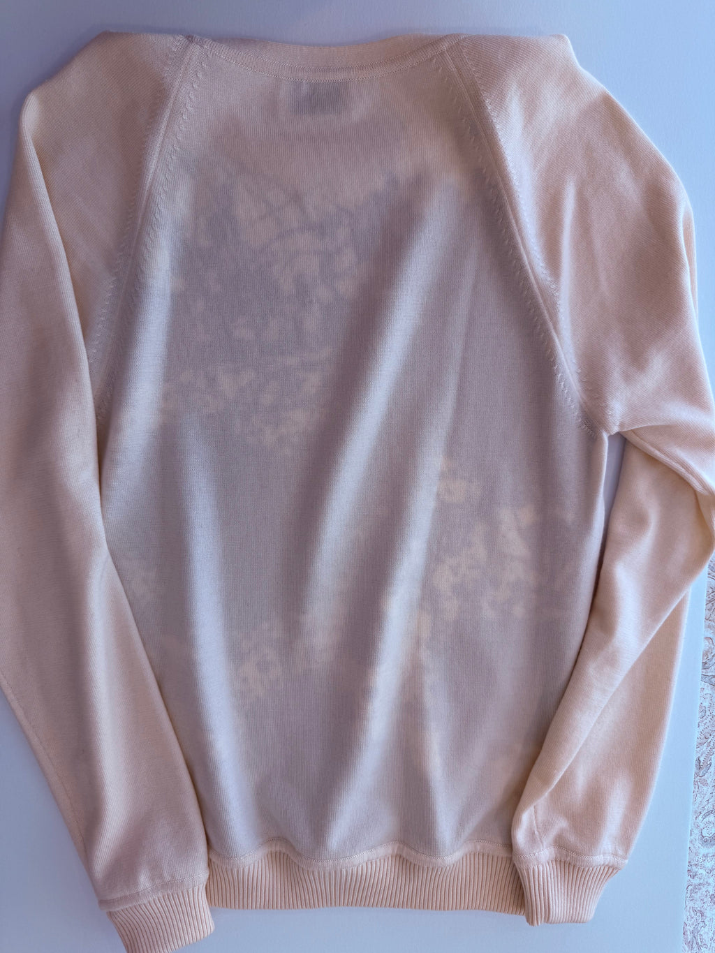 Back of the Hermès Cheval Surprise sweater in cream virgin wool knit, laid flat 