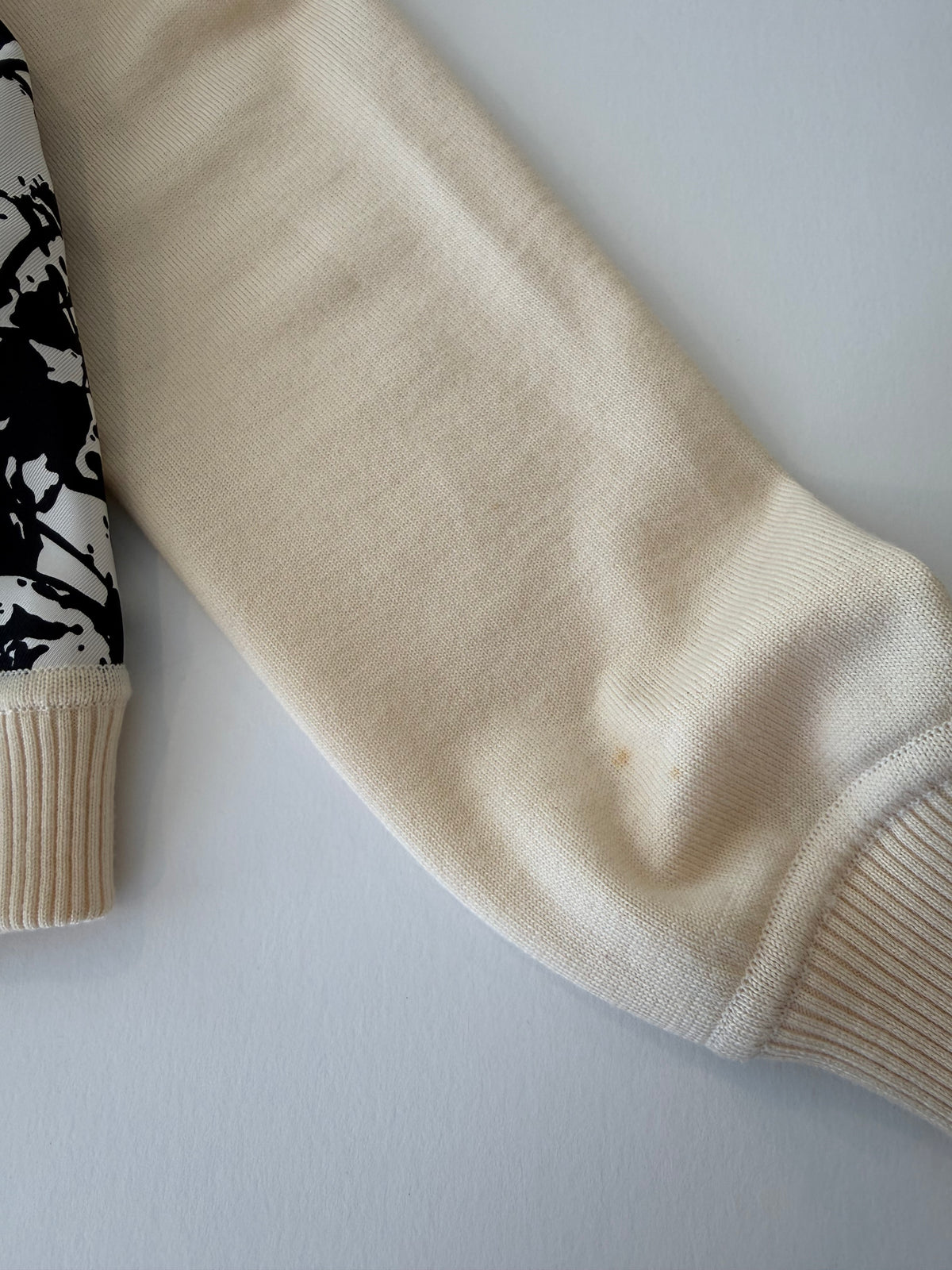 Cream raglan sleeve with ribbed cuff on the Hermès Cheval Surprise knit sweater, small flaw
