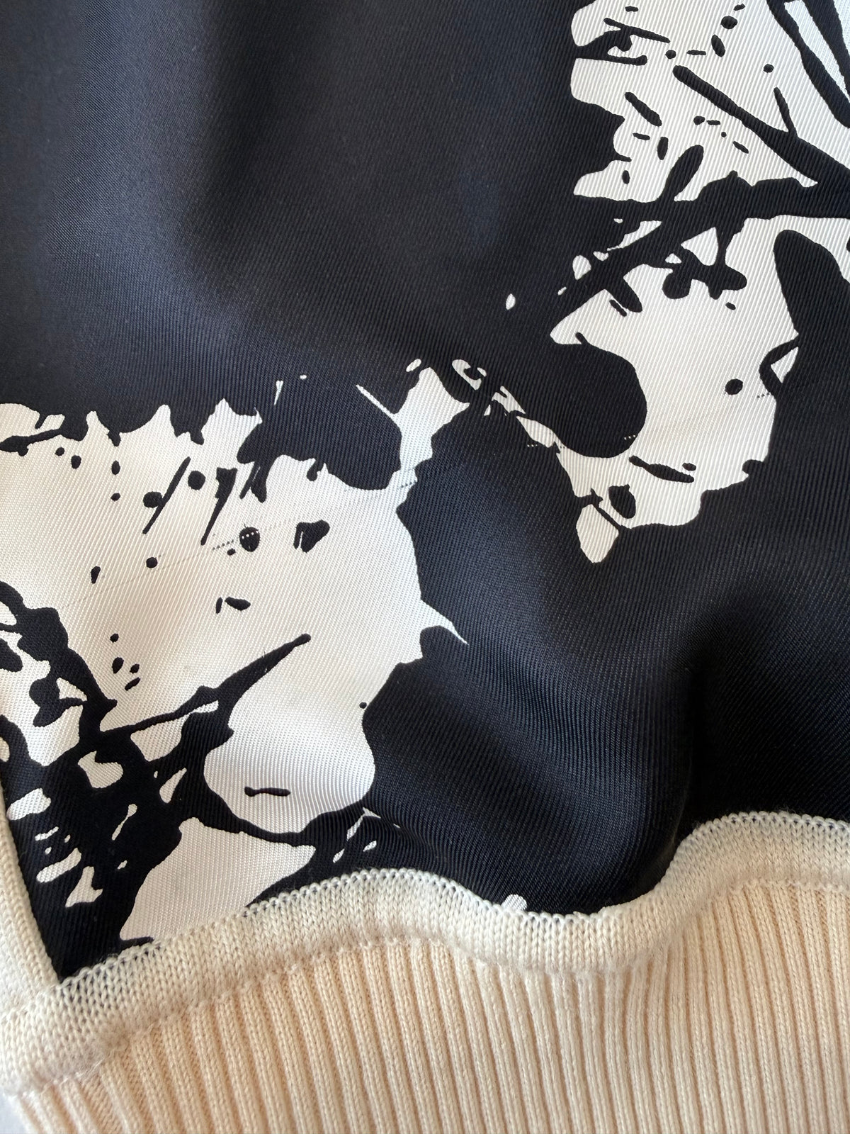 Black-and-white splatter graphic on the Hermès Cheval Surprise sweater, small flaw detail